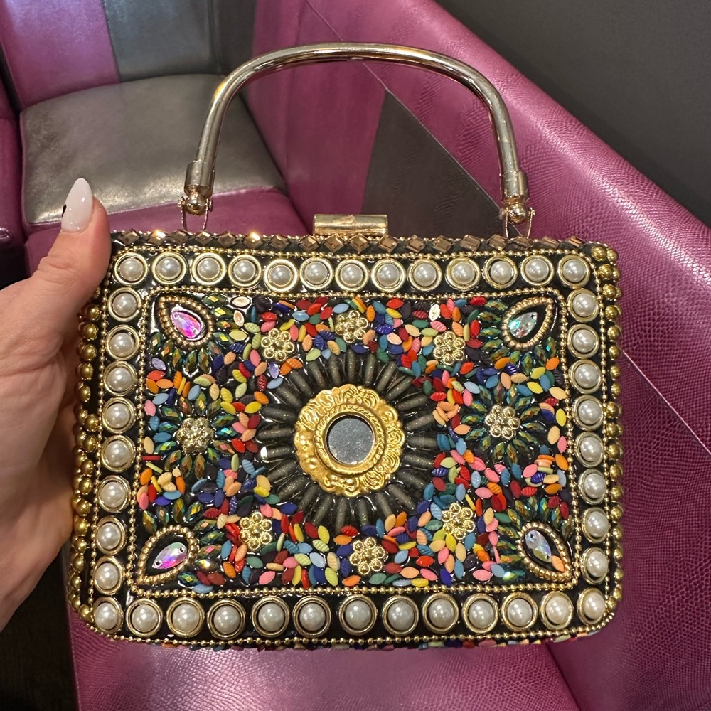 Small jeweled hand bag gold mental frame and strap.